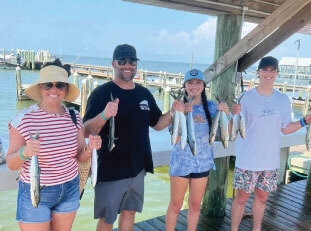 people with fish they caught at off the hook charters 8