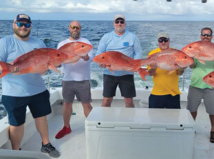 people with fish they caught at off the hook charters 13